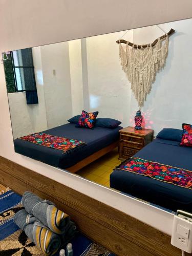 a room with two beds and a large mirror at La Casa De Don Rámon in Guadalajara