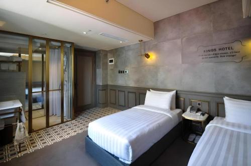 - une chambre d'hôtel avec 2 lits et un téléphone dans l'établissement King's Hotel, à Hong Kong