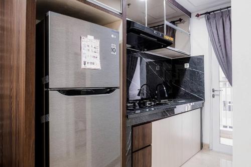 a kitchen with a stainless steel refrigerator and a stove at Apartemen 2 Kamar Podomoro in Medan