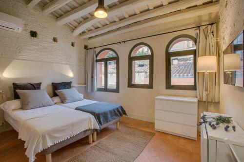 1 dormitorio con 2 camas en una habitación con ventanas en Flateli Ballesteries, en Girona