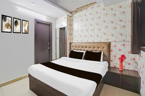 a bedroom with a large bed and a wall at Collection O Prabhat Nagar Bareilly in Bareilly