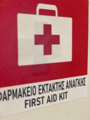 a sign for a first aid kit with a red cross on it at Lithéa, stone residence in Nafplio