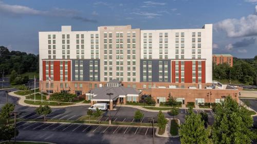 a large white building with red and black windows at Hilton Garden Inn Hanover Arundel Mills, MD in Hanover