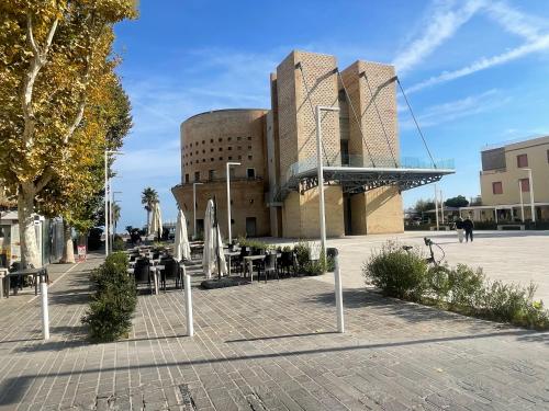 a building with tables and chairs in front of it at Sweet NiMa in Francavilla al Mare