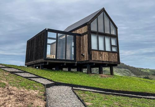 a house on top of a hill with glass at Rio Arriba Ecoloft in El Culenar