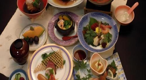 a table with plates of food and bowls of food at Hotel Kaanapali in Shirako