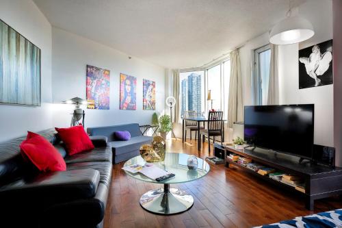 a living room with a couch and a flat screen tv at Beautiful APARTMENT - GORGEOUS VIEW of the city - 7 MINUTE WALK TO METRO - SELF CHECK IN in Montréal