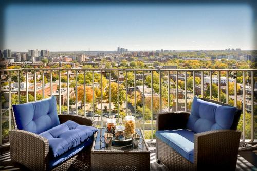 a balcony with chairs and a view of a city at Beautiful APARTMENT - GORGEOUS VIEW of the city - 7 MINUTE WALK TO METRO - SELF CHECK IN in Montréal