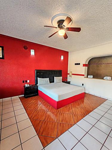 a bedroom with a bed and a red wall at Loma Bonita - Hotel Zapopan in Guadalajara