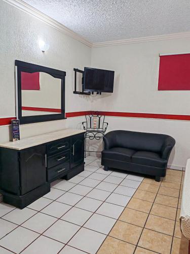 a living room with a black couch and a mirror at Loma Bonita - Hotel Zapopan in Guadalajara