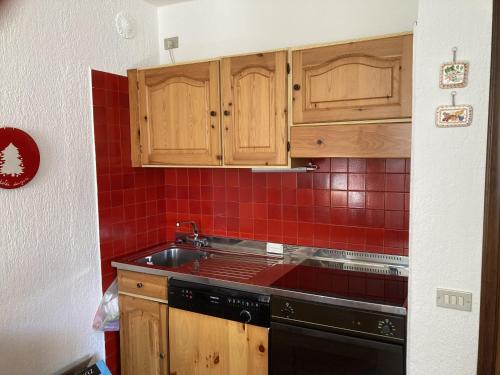 a kitchen with wooden cabinets and a black stove at 031 Trilocale piano terra, Giustino in Giustino