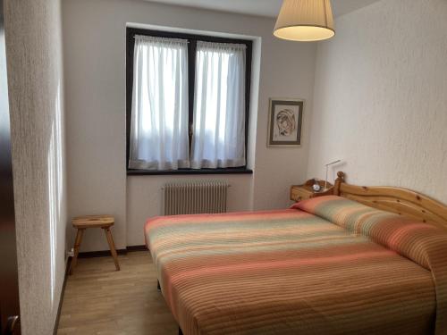 a bedroom with a bed and a window at 031 Trilocale piano terra, Giustino in Giustino