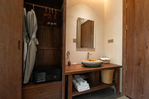 a bathroom with a counter with a sink and a mirror at Chaoyangli Folk Resort Hotel in Zhaoqing