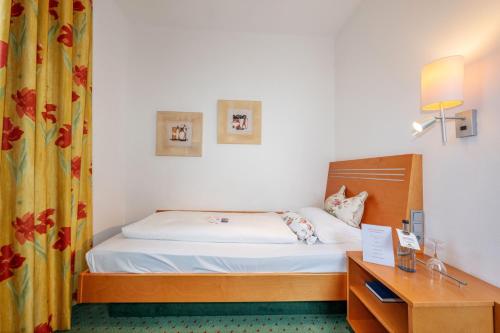 a hotel room with a bed and a desk and a bed at Hotel Kloster Hirsau in Calw