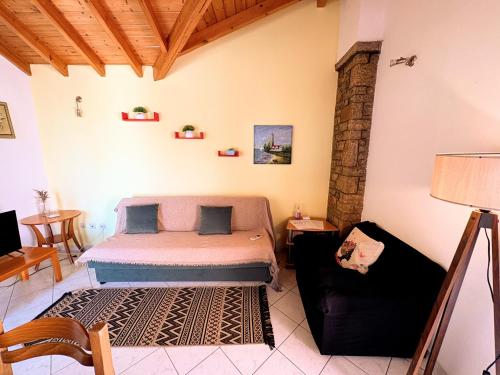 a bedroom with a bed and a couch in a room at Eva's Apartments in Karlovasi