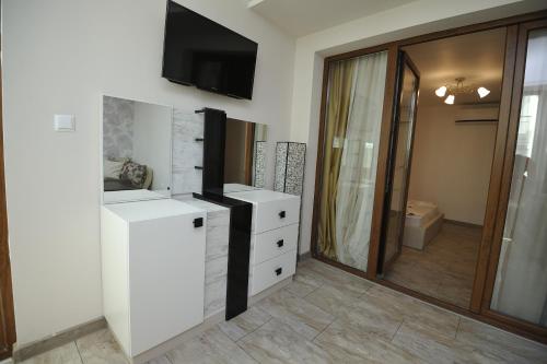 ヴァルナ・シティにあるPoshta 1 Apartment 2のバスルーム(白いドレッサー、壁掛けテレビ付)