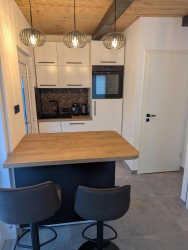 a kitchen with a counter with two chairs and lights at Wasserschloss Apt - von Taube Refugium für 1-2 Personen mit Terasse, Küche, Garten, Wifi, TV, Bar, Dusche, Waschmaschine, Parkplatz, versteckt gelegen in Neukirchen