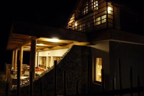 a house with lights on the side of it at night at Guest House Eco Vila Mila in Rogaška Slatina