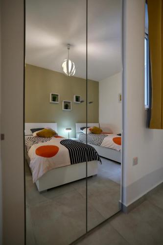 a bedroom with two beds and a large mirror at St Paul's Apt Distant SeaViews in St. Paul's Bay