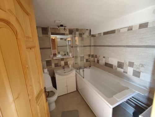 a bathroom with a tub and a toilet and a sink at Casa Utan in Văleni