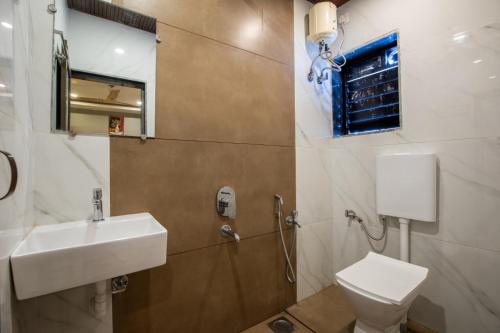 a bathroom with a sink and a toilet at Hotel Stay Land Inn Versova in Mumbai