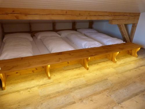 a wooden bunk bed with white pillows on it at Berglodge Ristis in Engelberg