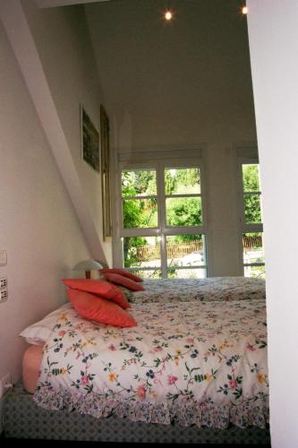 une chambre avec un lit avec des oreillers rouges et une fenêtre dans l'établissement Loft de Cannes B&B, à Cannes