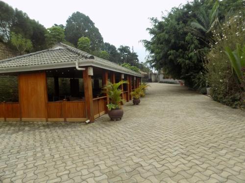 a building with a pavilion with potted plants on it at Fort Fun City Hotel Fort Portal in Fort Portal