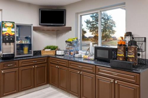 a kitchen with a counter top with a microwave at Super 8 by Wyndham Latham - Albany Airport in Latham