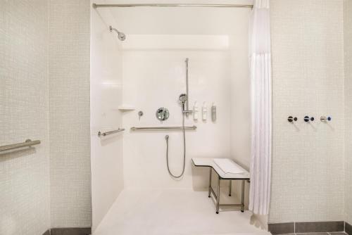 a white bathroom with a shower and a sink at Hampton Inn Fort Myers Downtown in Fort Myers