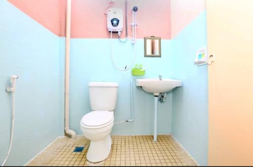 a bathroom with a toilet and a sink at Pelangi Marang by Tanjung Sukai in Marang