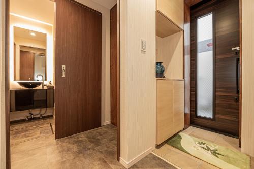 a hallway with a bathroom with a sink and a door at KTV Party House 3min to Itabashi Station Traditional Street Stay in Tokyo