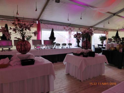a tent with two tables and vases with flowers at Hotel Restaurant Cafe Houben in Nunhem