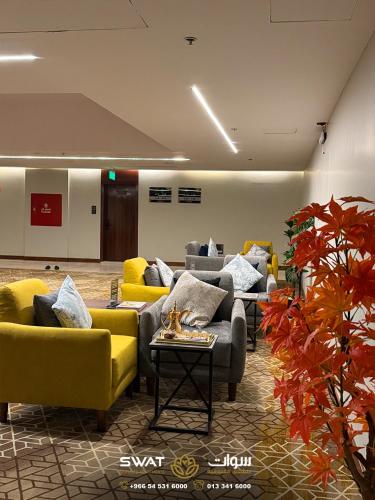 a living room with couches and yellow chairs at سوات للشقق المخدومة 5 in Al Khobar