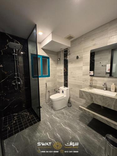 a bathroom with a toilet and a sink and a shower at سوات للشقق المخدومة 5 in Al Khobar