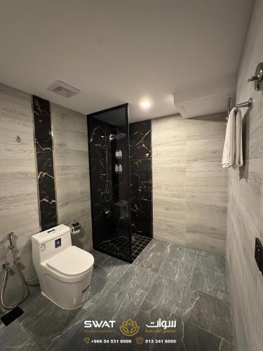 a bathroom with a toilet and a shower at سوات للشقق المخدومة 5 in Al Khobar