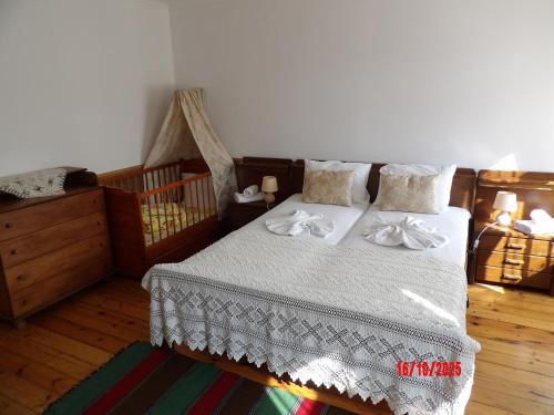 a bedroom with a bed with white sheets and pillows at Етаж от Хаджи Марковата къща за гости - град Дряново in Dryanovo