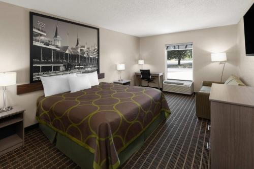 a hotel room with a large bed and a desk at Super 8 by Wyndham Shepherdsville - Louisville South I65 in Shepherdsville