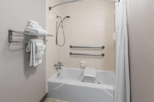 a bathroom with a tub and a toilet and towels at Days Inn by Wyndham Cambridge in Cambridge