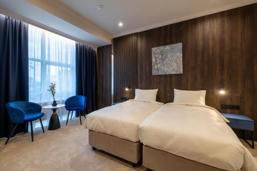 a bedroom with a large bed and a blue chair at Art Hotel in Chişinău