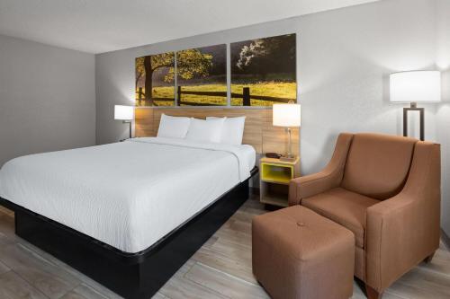 a hotel room with a bed and a chair at Days Inn by Wyndham Blairsville in Blairsville