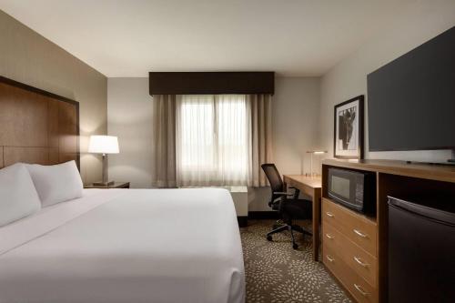 a hotel room with a bed and a desk and a television at La Quinta by Wyndham Fairbanks Airport in Fairbanks