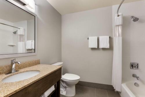 a bathroom with a sink and a toilet and a tub at La Quinta by Wyndham Fairbanks Airport in Fairbanks