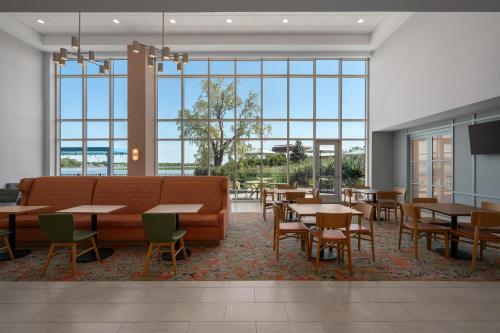 a dining room with tables and chairs and large windows at Hampton Inn & Suites By Hilton Port Clinton Catawba Island in Port Clinton