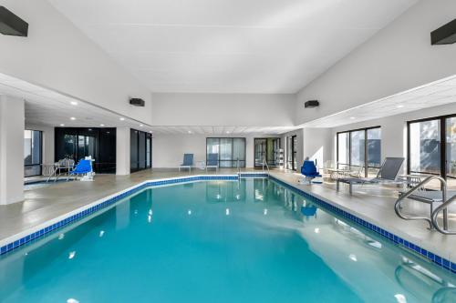 a swimming pool with blue water in a building at Spark by Hilton Green Bay in Green Bay