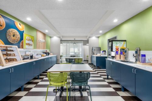 a cafeteria with blue cabinets and green walls and a table and chairs at Spark by Hilton Green Bay in Green Bay