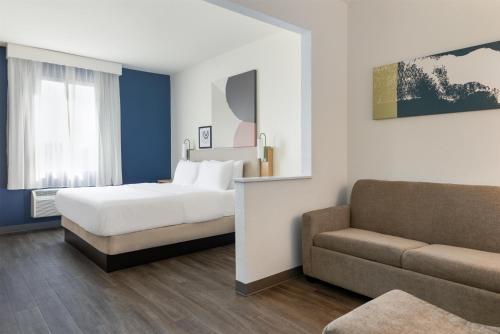 a hotel room with a bed and a couch at Spark by Hilton Indianapolis Northeast Fishers in Fishers