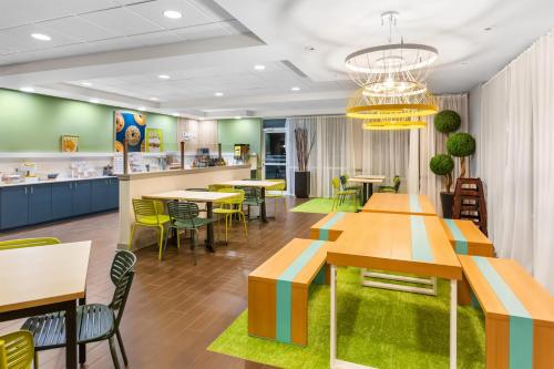 a restaurant with tables and chairs and a cafeteria at Spark by Hilton Dothan in Dothan
