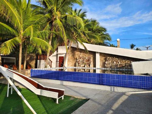 a swimming pool with a bench and palm trees at J's PALM BEACH Resort in Batangas City
