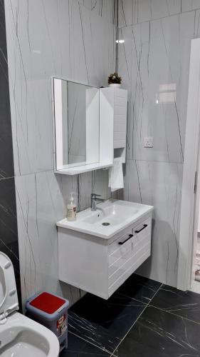 a white bathroom with a sink and a mirror at Kathy's place in Nyali in Mombasa